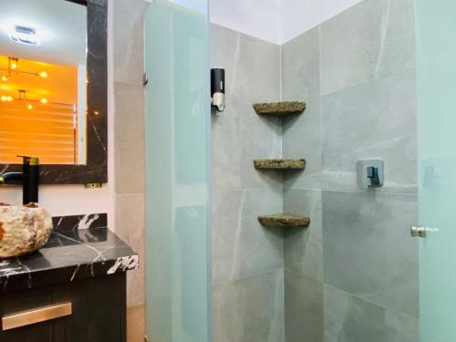 a bathroom with a shower with a sink and a mirror at Luxurious and Modern Apartment in North Zone in Aguascalientes