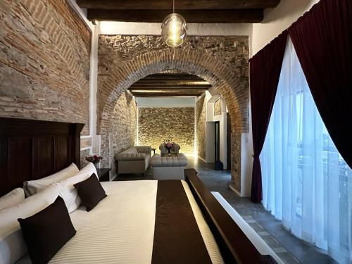 een slaapkamer met een groot bed en een bakstenen muur bij HOTEL BOUTIQUE CASONA 65 in Puebla