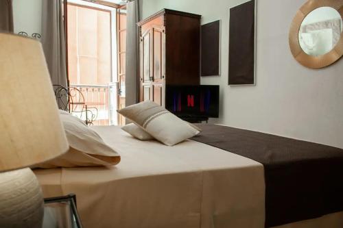 sypialnia z łóżkiem z lustrem na ścianie w obiekcie Castello's Rooms w Cagliari