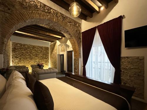 a bedroom with a large bed and a brick wall at HOTEL BOUTIQUE CASONA 65 in Puebla