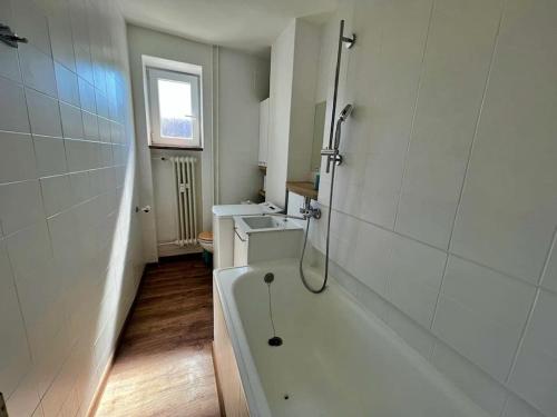 a white bathroom with a tub and a sink at Apartmán v centre in Banská Bystrica