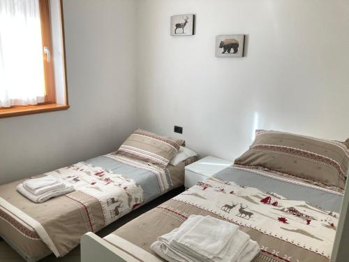 sypialnia z dwoma łóżkami i oknem w obiekcie Adamello Brenta Sunshine w Madonna di Campiglio