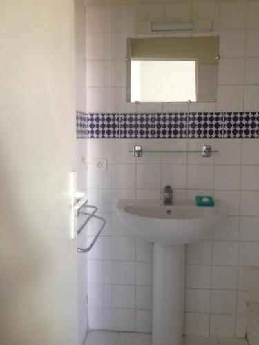 W łazience znajduje się umywalka i lustro. w obiekcie Minori w Montpellier