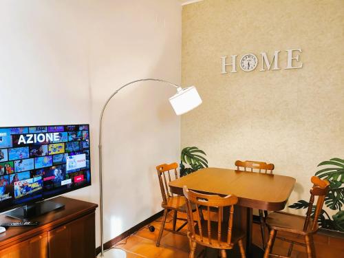 奧斯蒂亞的住宿－OSTIA HOME，一间带桌子和电视的用餐室