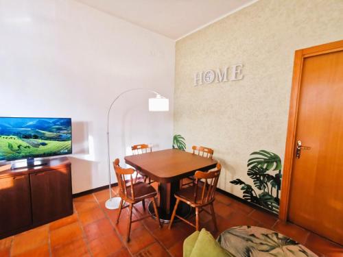 a dining room with a table and a tv at OSTIA HOME in Lido di Ostia