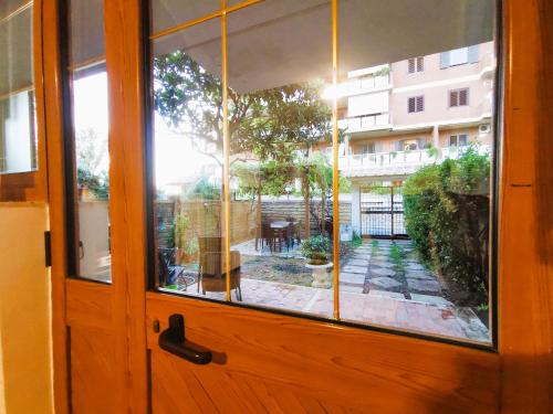 a wooden door with a view of a patio through a window at OSTIA HOME in Lido di Ostia