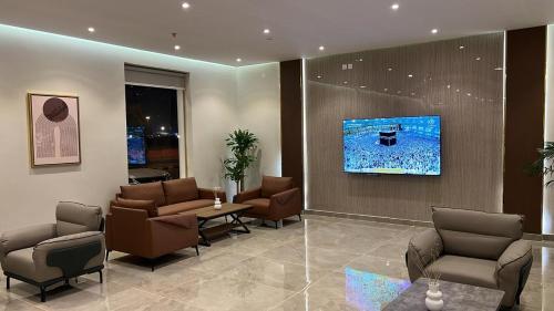 una sala de espera con sillas y TV en la pared en فندق دره الراشد للشقق المخدومه en Riad