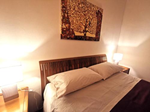 a bed in a bedroom with a picture on the wall at OSTIA HOME in Lido di Ostia