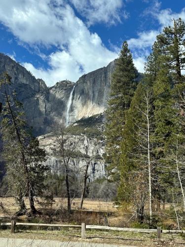 a waterfall in front of a mountain with trees at Yosemite Condominium Loft unit -B202 in Yosemite West