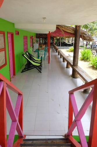 a restaurant with green and pink walls and tables and chairs at Cabaña en primera línea de playa en San Antero con Aire AC y 5 habitaciones in San Antero