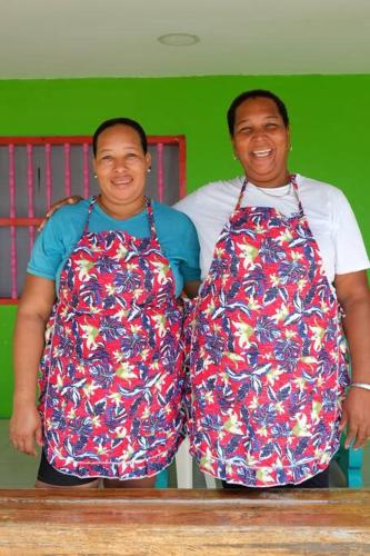 two men wearing aprons standing next to each other at Cabaña en primera línea de playa en San Antero con Aire AC y 5 habitaciones in San Antero