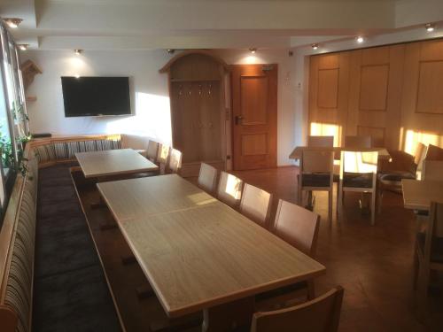 a restaurant with tables and chairs and a flat screen tv at Gasthof Zur Krone in Leidersbach
