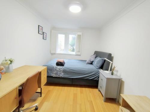a small bedroom with a bed and a desk at Spacious 3-Bed Cosy Flat in Westminster in London