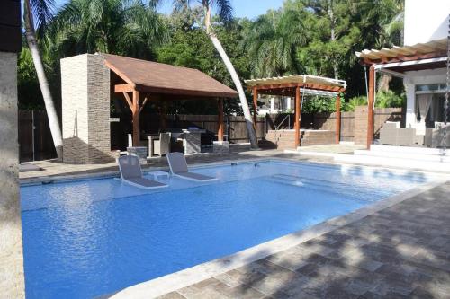 a swimming pool with two chairs and a gazebo at Villa Palma -Private villa in the mountains in La Cuaba