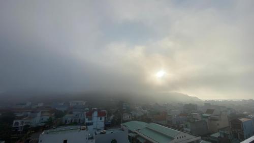 a foggy city with the sun in the background at Khách Sạn Nhơn Lý LYS HOTEL in Quy Nhon