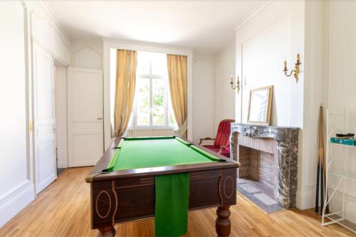 a pool table in a room with a fireplace at Manoir romantique 8 mn du lac et 2 heures de Paris in Montier-en-Der
