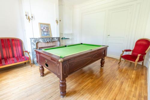 a room with a pool table and two chairs at Manoir romantique 8 mn du lac et 2 heures de Paris in Montier-en-Der