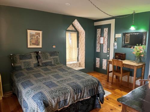 um quarto com uma cama, uma mesa e uma janela em Manoir Guay Lafontaine em Rimouski