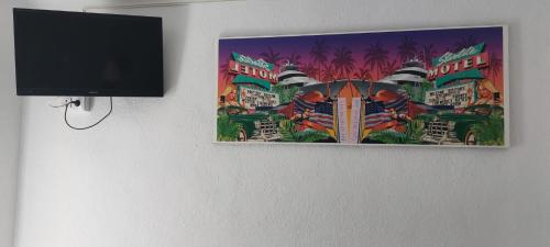 a picture hanging on a wall next to a tv at SB Arenal in El Arenal