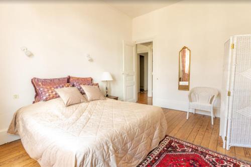 a bedroom with a large bed and a chair at Manoir romantique 8 mn du lac et 2 heures de Paris in Montier-en-Der