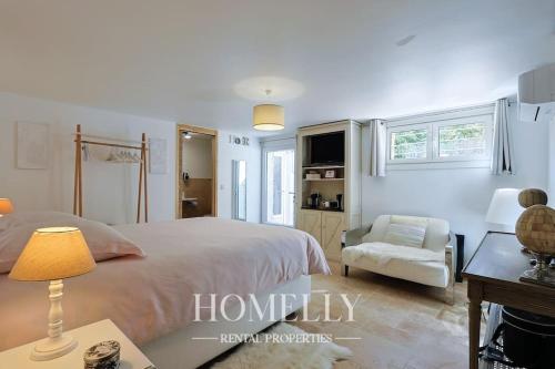 une chambre blanche avec un lit et une chaise dans l'établissement Villa élégante avec piscine à Saint-Tropez - Villa Chrystal, à Saint-Tropez