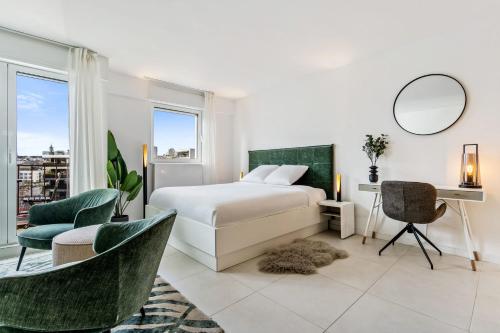 a bedroom with a bed and a desk and chairs at Stylish Studio with King Bed, Balcony and Full Kitchen in Luxembourg