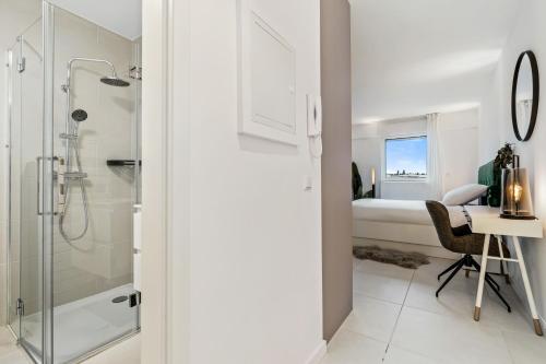 a bathroom with a shower and a desk and a bed at Bright Belair Gem Experience the City in Style in Luxembourg