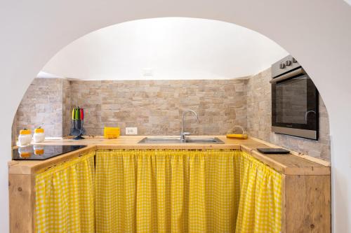 a kitchen with a yellow checkered counter top at La Villa - Rainbow House in Martina Franca