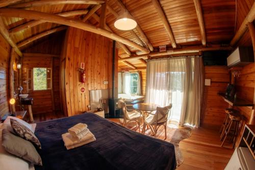 a bedroom with a large bed in a cabin at Hospedaria Refugio do Invernador in Urubici