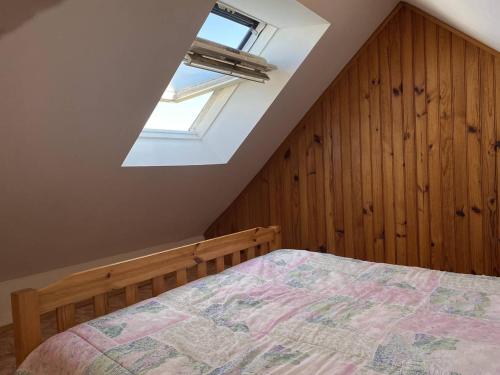 une chambre avec un lit et une lucarne dans l'établissement 491 - Maison unique, les pieds dans l'eau, le long de la plage de Saint-Pabu, à Erquy