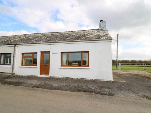 a white house with brown doors and windows at Blaenferwig in New Quay