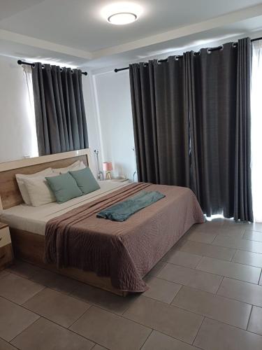 a bedroom with a large bed with gray curtains at The Edge in Accra