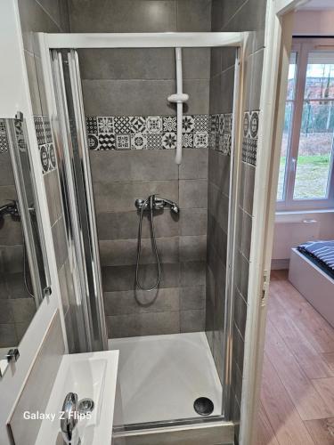 a bathroom with a shower with a glass door at Chambre DUO in Beauvais