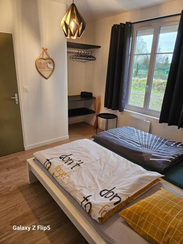 a bedroom with two beds and a window at Chambre DUO in Beauvais