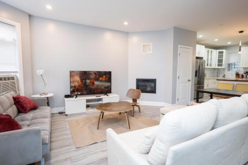 ein Wohnzimmer mit weißen Möbeln und einem Flachbild-TV in der Unterkunft Newark's Family Favorite Place in Newark
