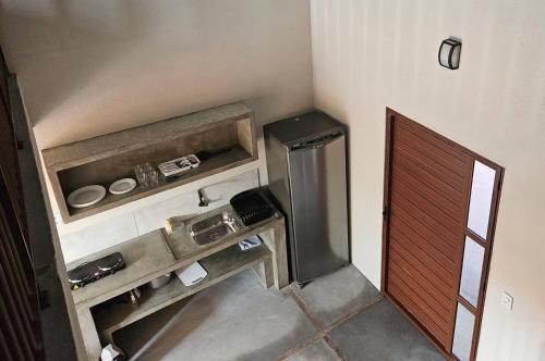 a small kitchen with a refrigerator in a room at Vila das Pedras in Cruz
