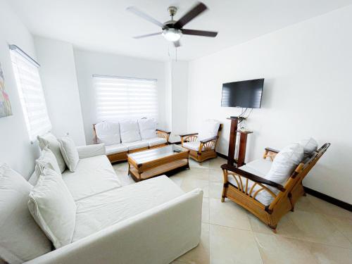 Il comprend un salon doté d'un mobilier blanc et d'une télévision à écran plat. dans l'établissement CARIBBEAN Paradise WIFi HOTEL BAVARO Beach CLUB & SPA, à Punta Cana
