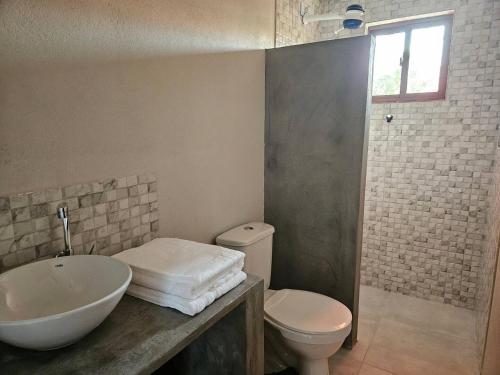 a bathroom with a sink and a toilet at Vila das Pedras in Cruz