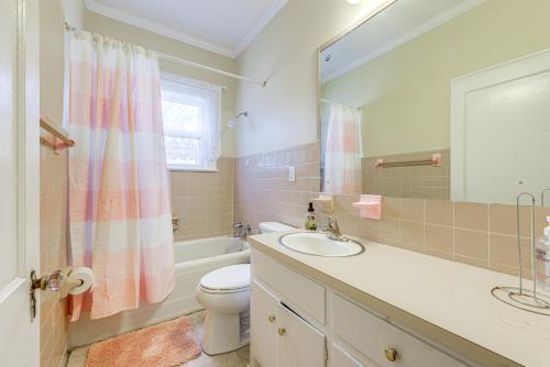 a bathroom with a sink and a toilet and a mirror at Sanford Vacation Rental about 1 Mi to Downtown! in Sanford