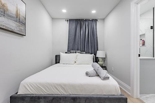 um quarto com uma cama branca e uma janela em Victoria Park Suite em Toronto