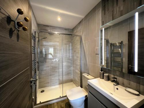 ein Bad mit einer Dusche, einem WC und einem Waschbecken in der Unterkunft 6 Breakwaters in Sandown