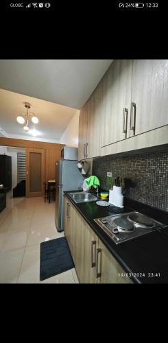 a kitchen with a sink and a refrigerator at Jans Staycation in Manila