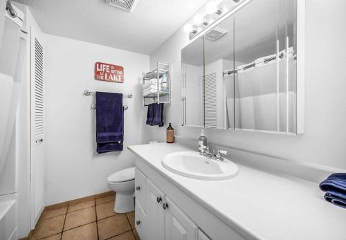 Baño blanco con lavabo y aseo en The Lakeside Condo #202, en West Kelowna