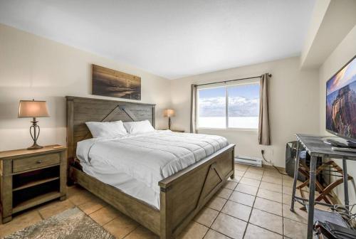 - une chambre avec un grand lit et une fenêtre dans l'établissement The Lakeside Condo #202, à West Kelowna