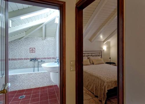 a bedroom with a bed and a tub and a sink at Villa Renata & Magic Suite in Parga