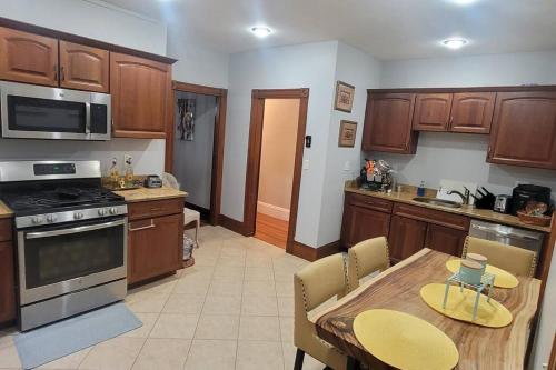 a kitchen with wooden cabinets and a wooden table with a dining room at Modern Haven ,Your Stylish Retreat in Boston