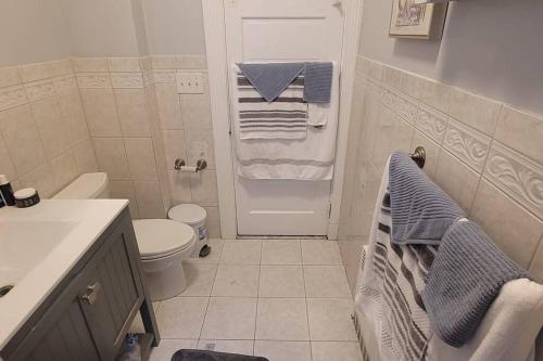a bathroom with a toilet and a shower with towels at Modern Haven ,Your Stylish Retreat in Boston