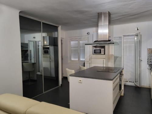 une cuisine blanche avec un comptoir et un canapé dans l'établissement Magnifique F3 tout équipé avec vue panoramique, à Ajaccio