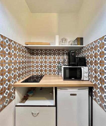 une petite cuisine avec un comptoir et un micro-ondes dans l'établissement Grand studio en hyper-centre, à Toulouse