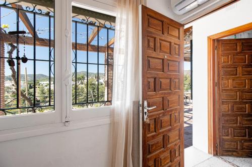a door leading into a room with windows at villa larwik frigiliana in Frigiliana